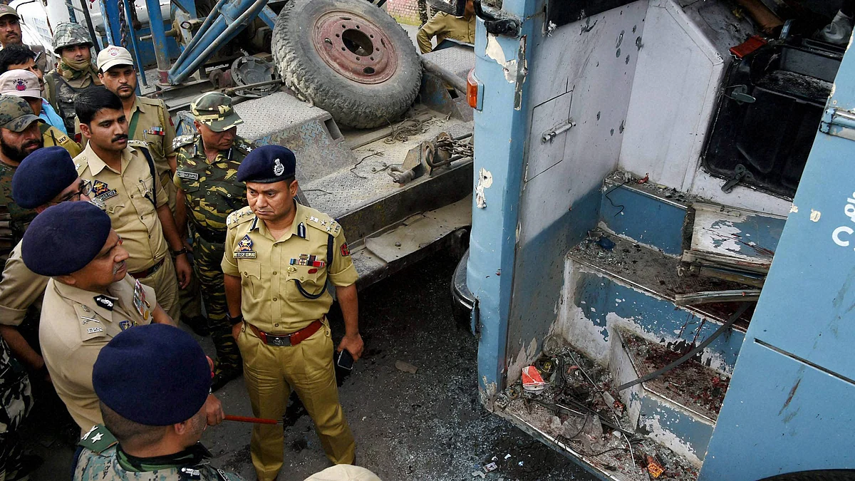 Security forces inspecting the CRPF bus attacked by LeT militants on the Srinagar-Jammu National Highway at Pampore in Srinagar, 25 June 2016. (Photo: PTI)