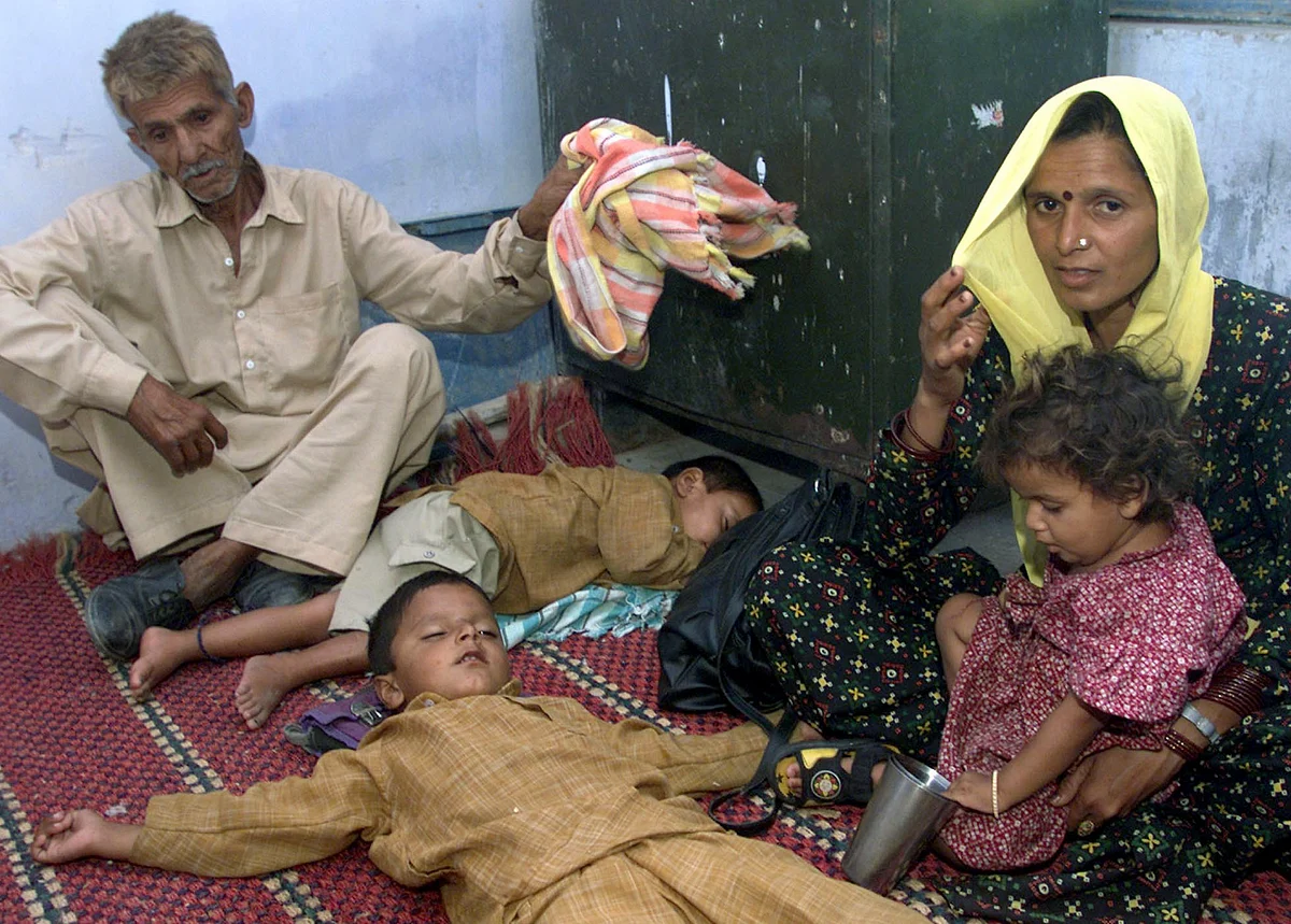 Kralu Ram, an elderly Hindu migrant from Pakistan, sits beside his two
sleeping grandsons and daughter-in-law. (Photo: Reuters)