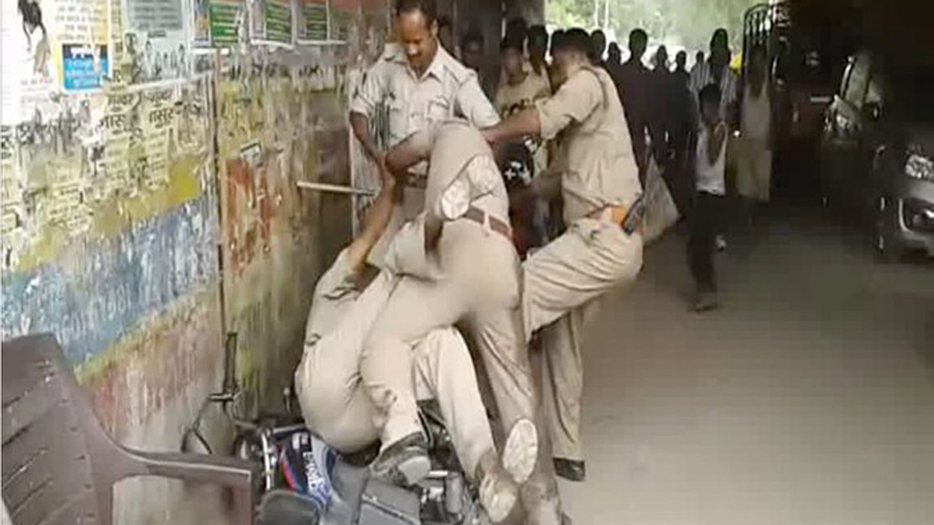 UP cops fight openly among themselves on a busy street in Lucknow as people watch on. (Photo Courtesy: ANI Screengrab)