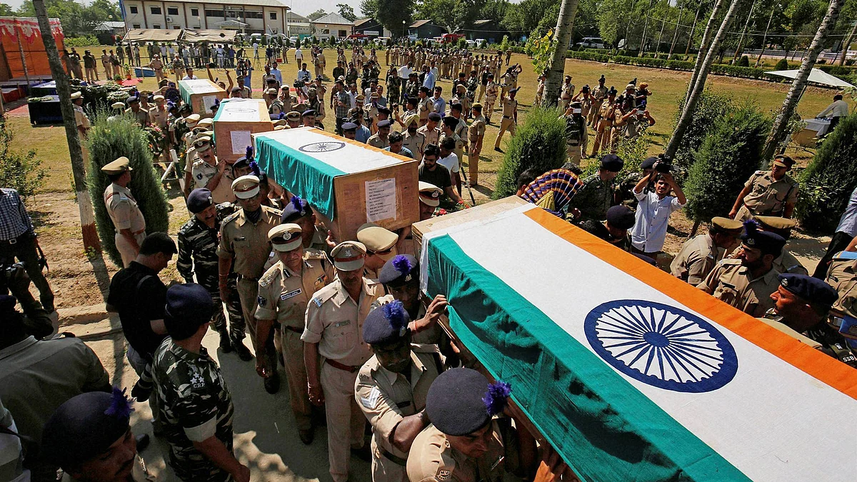 Senior police and CRPF officers carry makeshift coffins containing the bodies of the slain troopers after a wreath-laying ceremony at Humhama, on the outskirts of Srinagar, 26 June 2016. (Photo: PTI)
