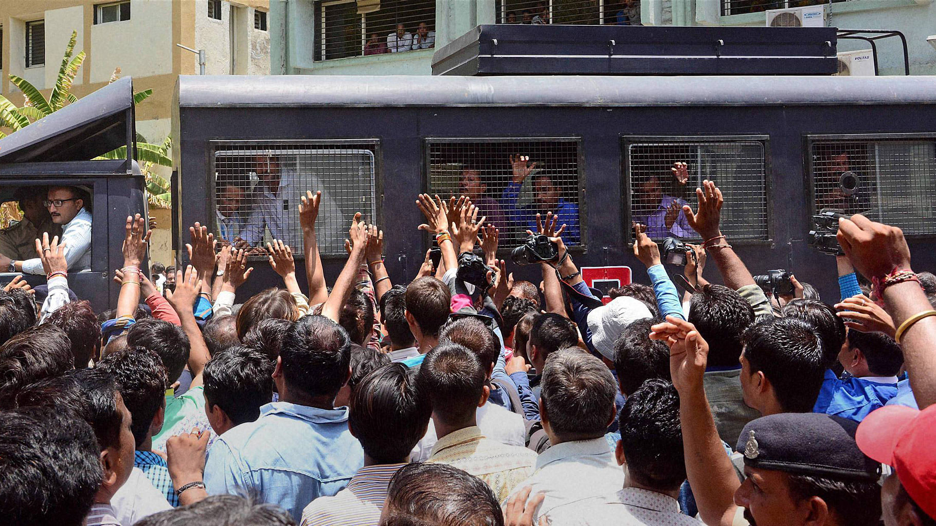 

Family members wave to the Gulbarg Society massacre case convicts as they are taken away in van, after the verdict   by a special SIT court in Ahmedabad on Thursday. (Photo: PTI)