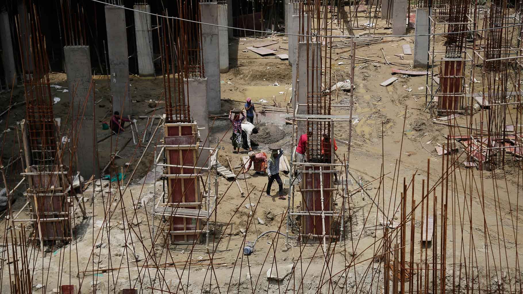 Laborers work at a construction site in Noida. ( Photo: AP)