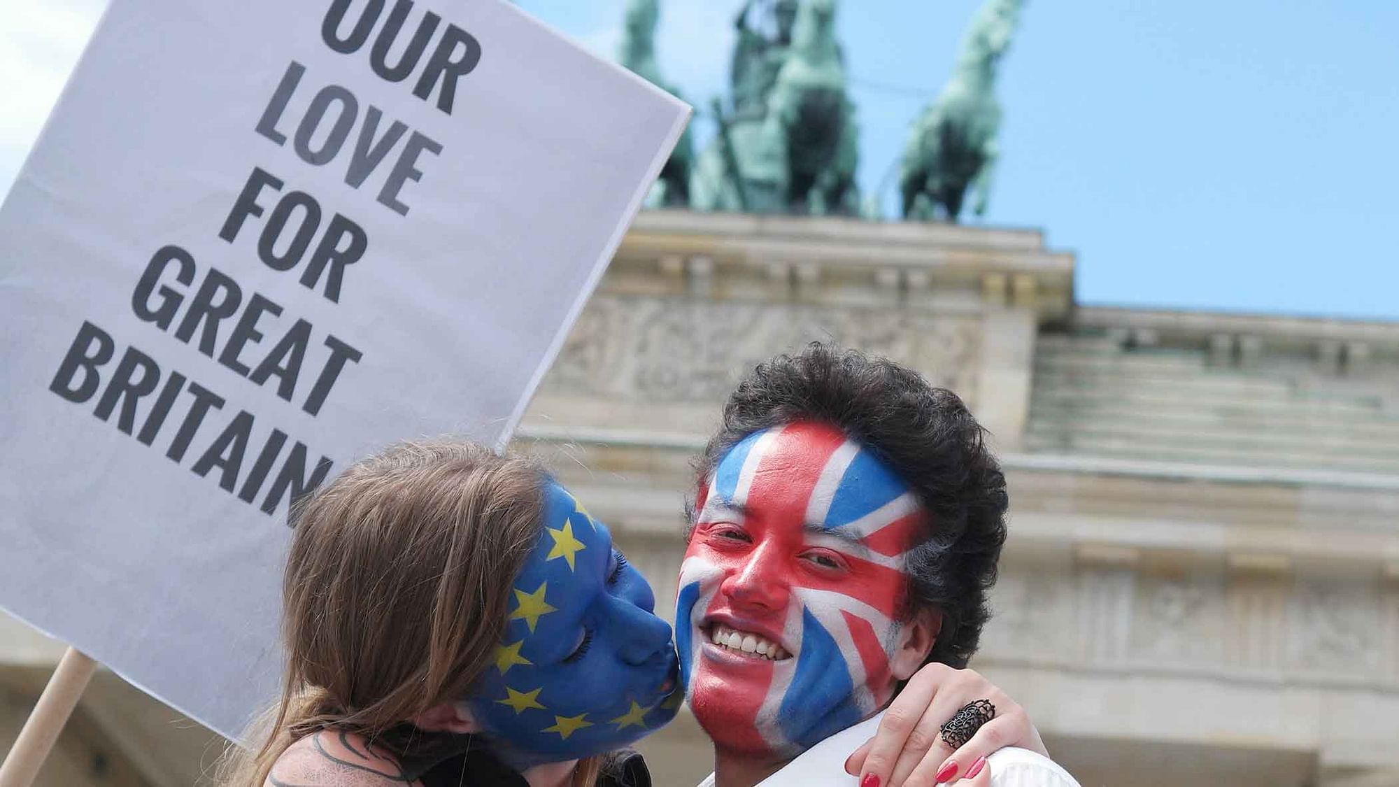 A young couple with faces paint in European Union, left, and British colors, pose with a sign “Our Love For Great Britain”  in Berlin on Sunday  to support the ‘ Remain’ voters in Britain’s referendum. (Photo: AP)