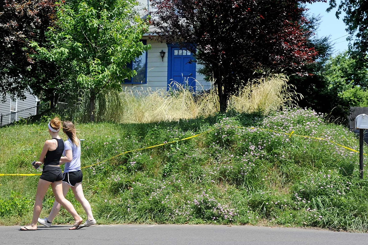 In this file photo from Saturday, 19 June 2016, two women walk past the home of Lee Kaplan in Feasterville, Pennsylvania. (Photo: AP)
