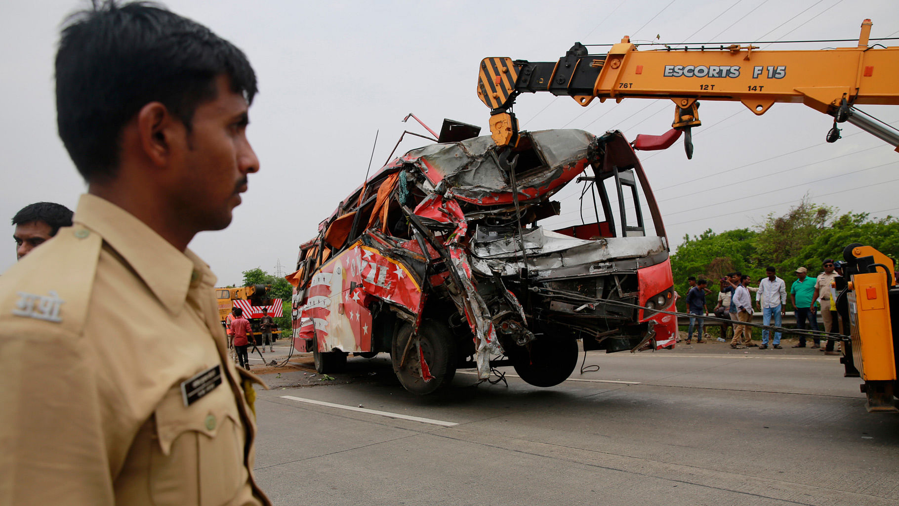A crane pulls a damaged bus after it met with an accident on the outskirts of Mumbai. (Photo: AP)