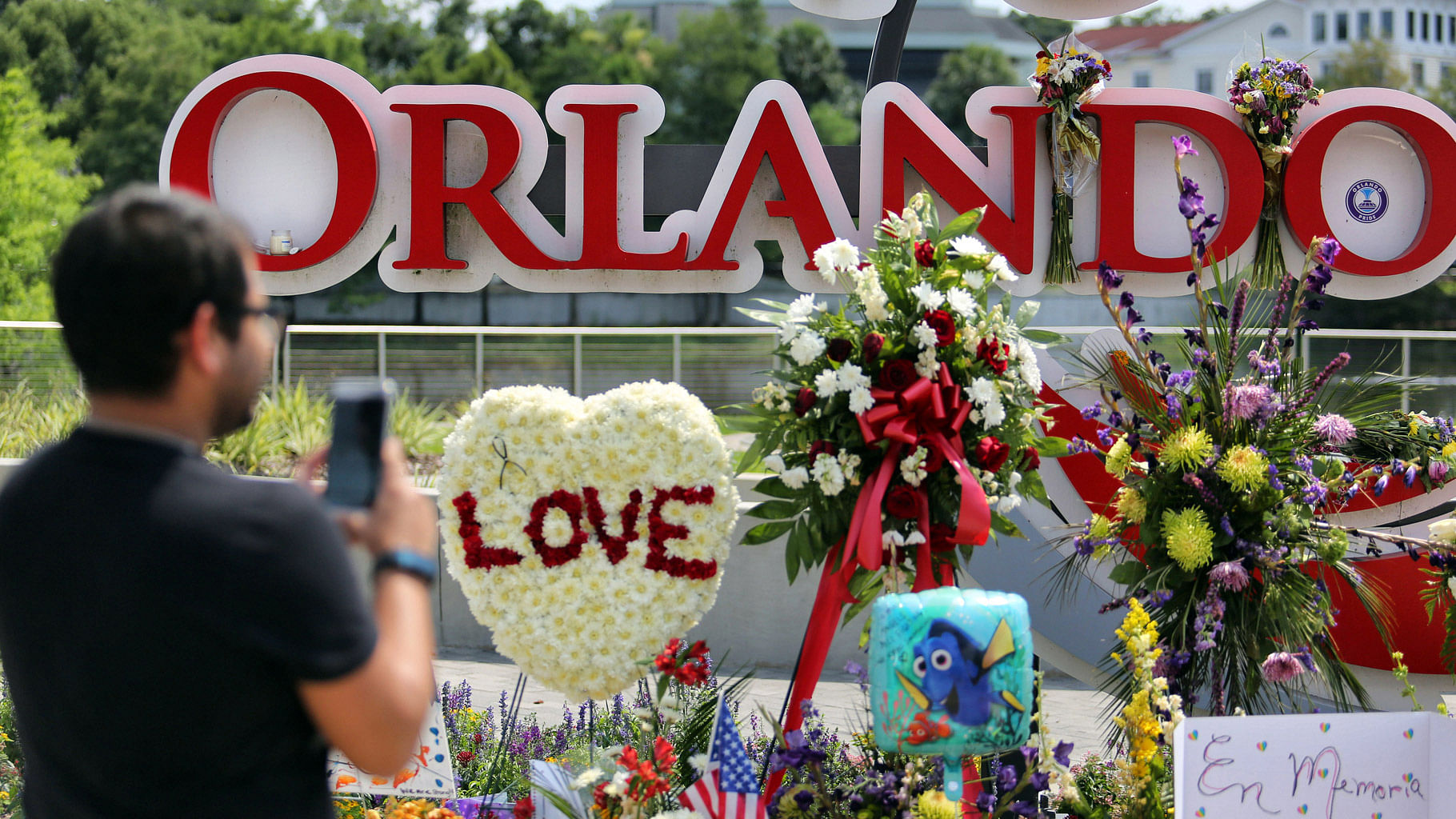 

A man takes a photo with his iPhone as visitors continue to pay their respects at a makeshift memorial at Orlando Regional Medical Center, a few blocks from the Pulse nightclub, Florida, June 14, 2016. (Photo: AP)