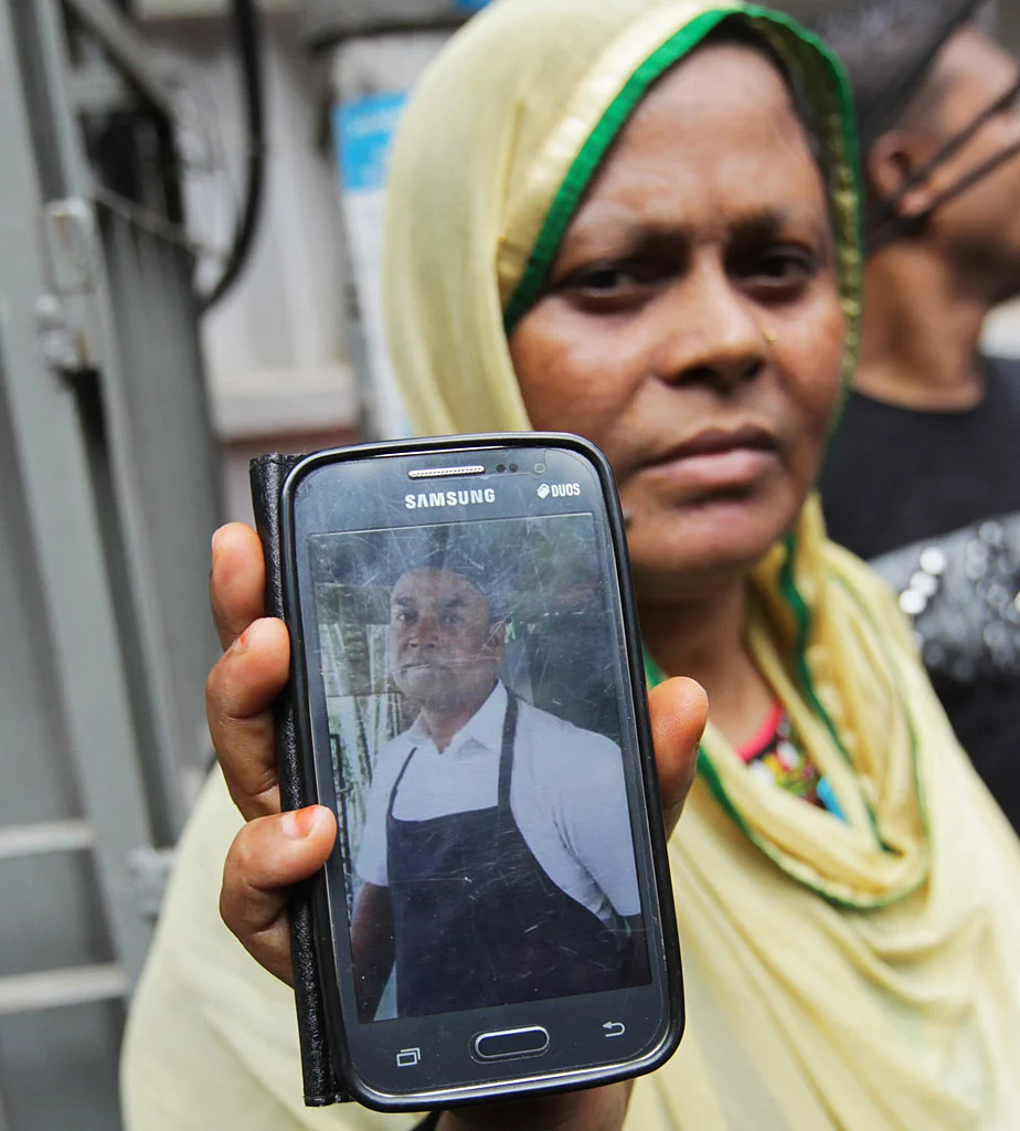 Johura Begum shows a photograph of her brother-in-law Saidul Islam, who works at the Holey Artisan Bakery and currently missing. (Photo: AP)
