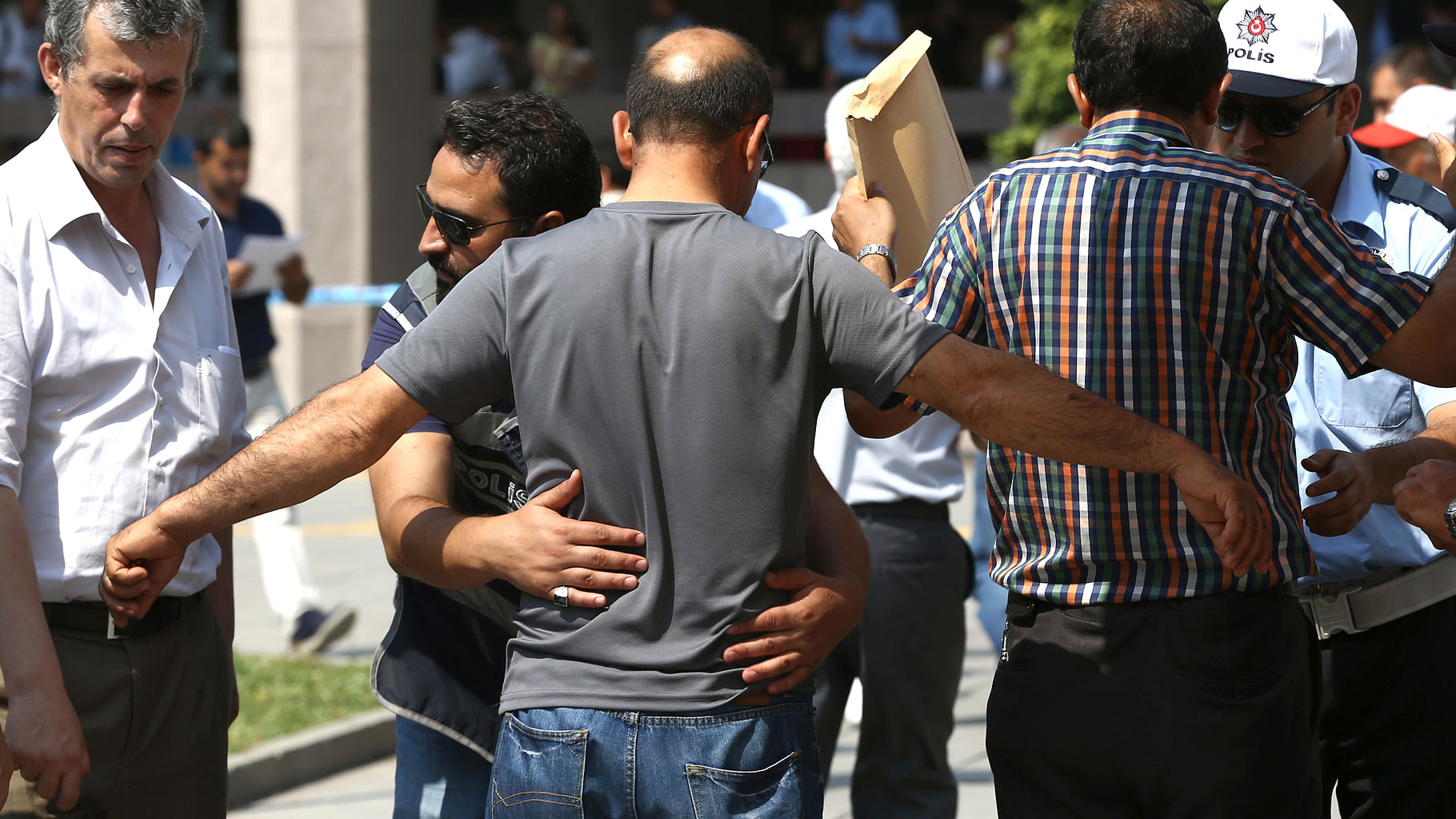 A Turkish policeman searches a man at the entrance of the courthouse where prosecutors are questioning several generals. (Photo Courtesy: AP)