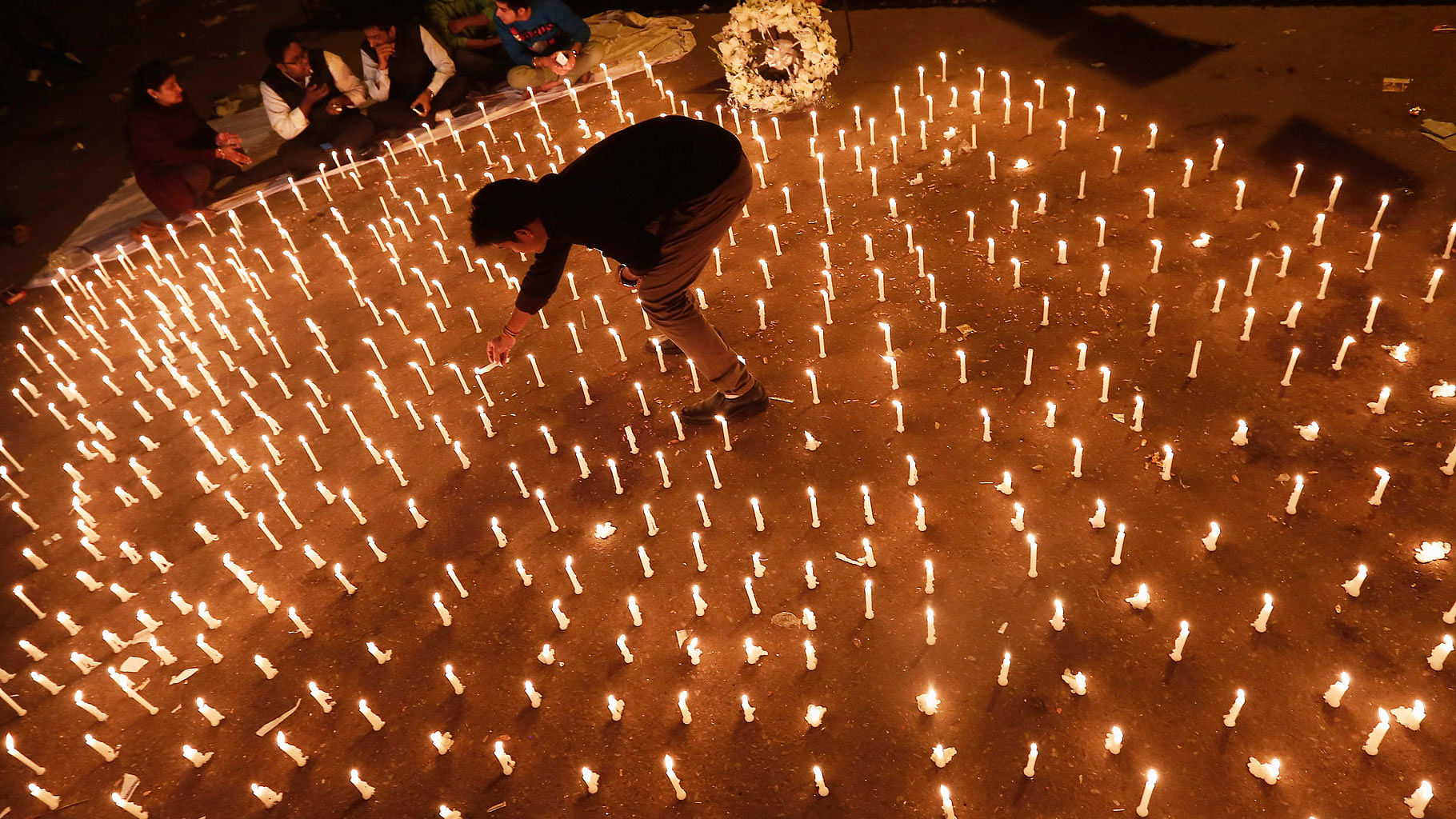 

A protester lights candles during a candlelight vigil to mark the first anniversary of the Delhi gangrape. (Photo: Reuters)