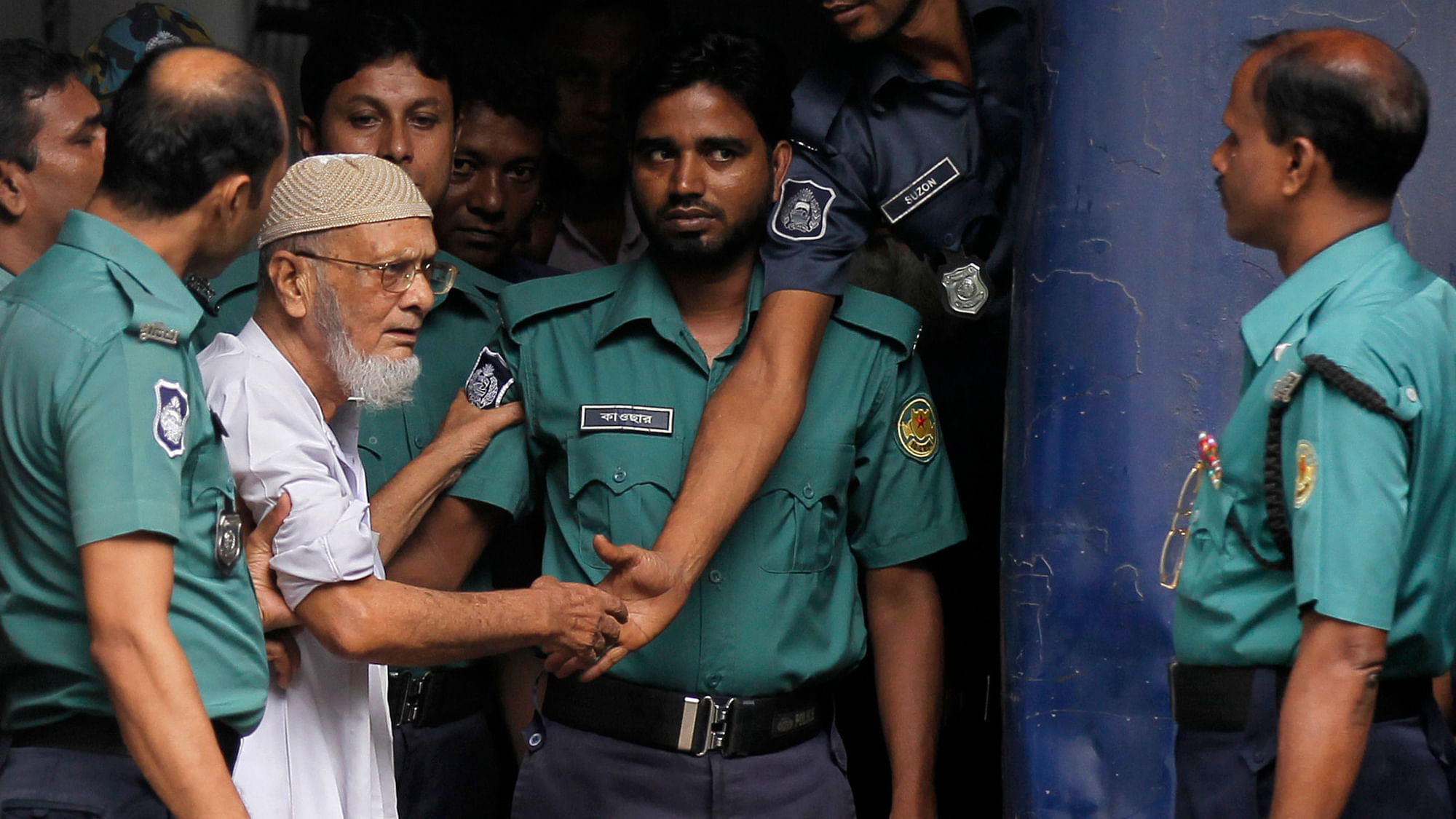 Bangladeshi policemen escort Shamsul Haque, third from left, after he was sentenced to life until death for his alleged involvement in war crimes in 1971. (Photo : AP)