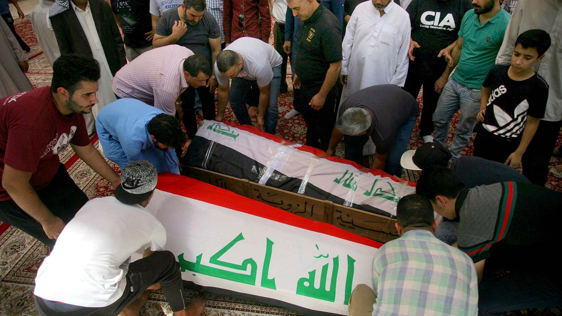 Mourners carry the Iraqi flag-draped coffins of bomb victims, Talib Hassan, 35, and Hamza Jabbar, 37, during their funeral processions. (Photo: AP)