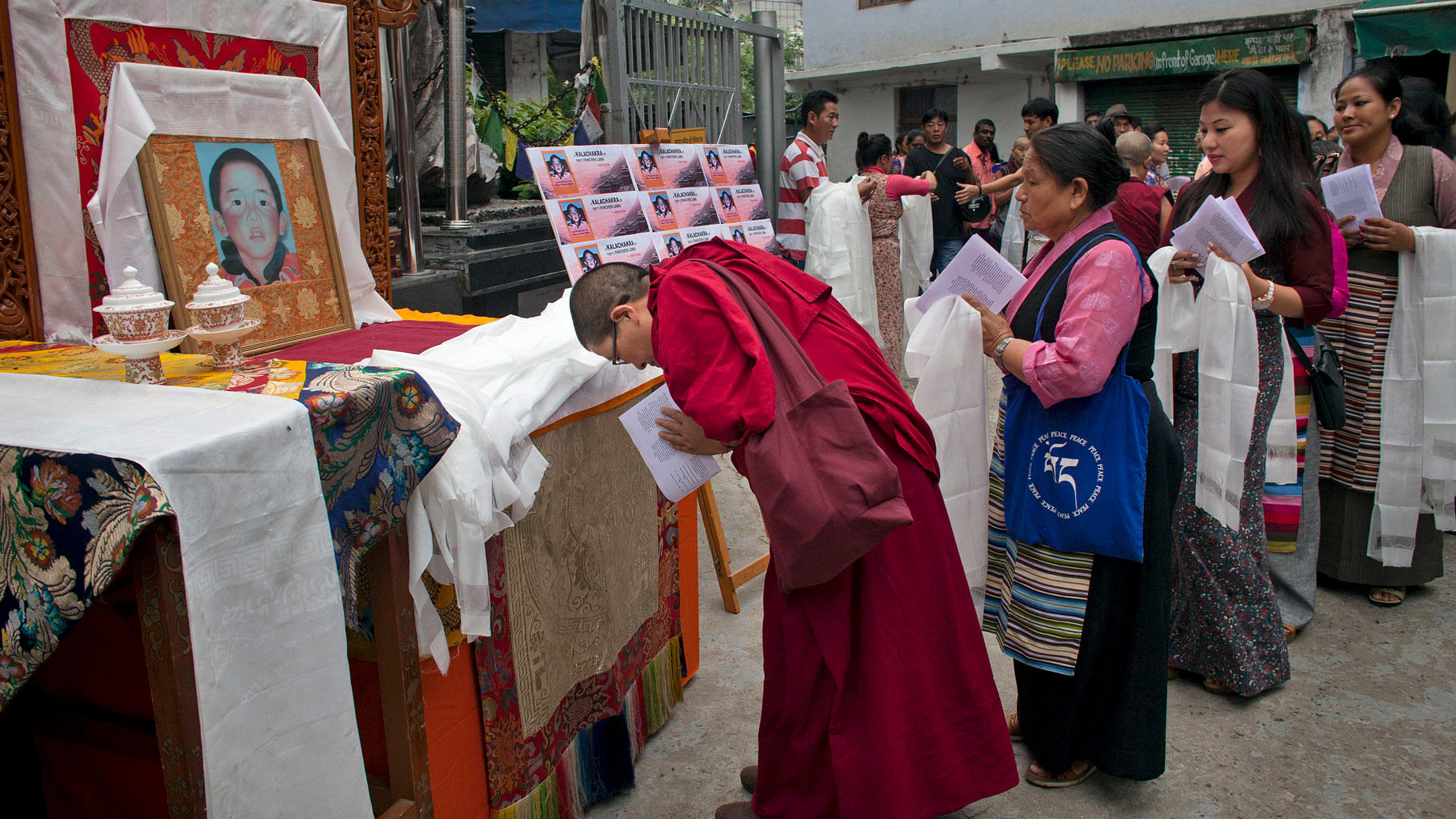 

Exiled Tibetans carry ceremonial scarves to offer them in front of a portrait of Tibetan spiritual leader, the 11th Panchen Lama in Dharmsala. (Photo: AP)