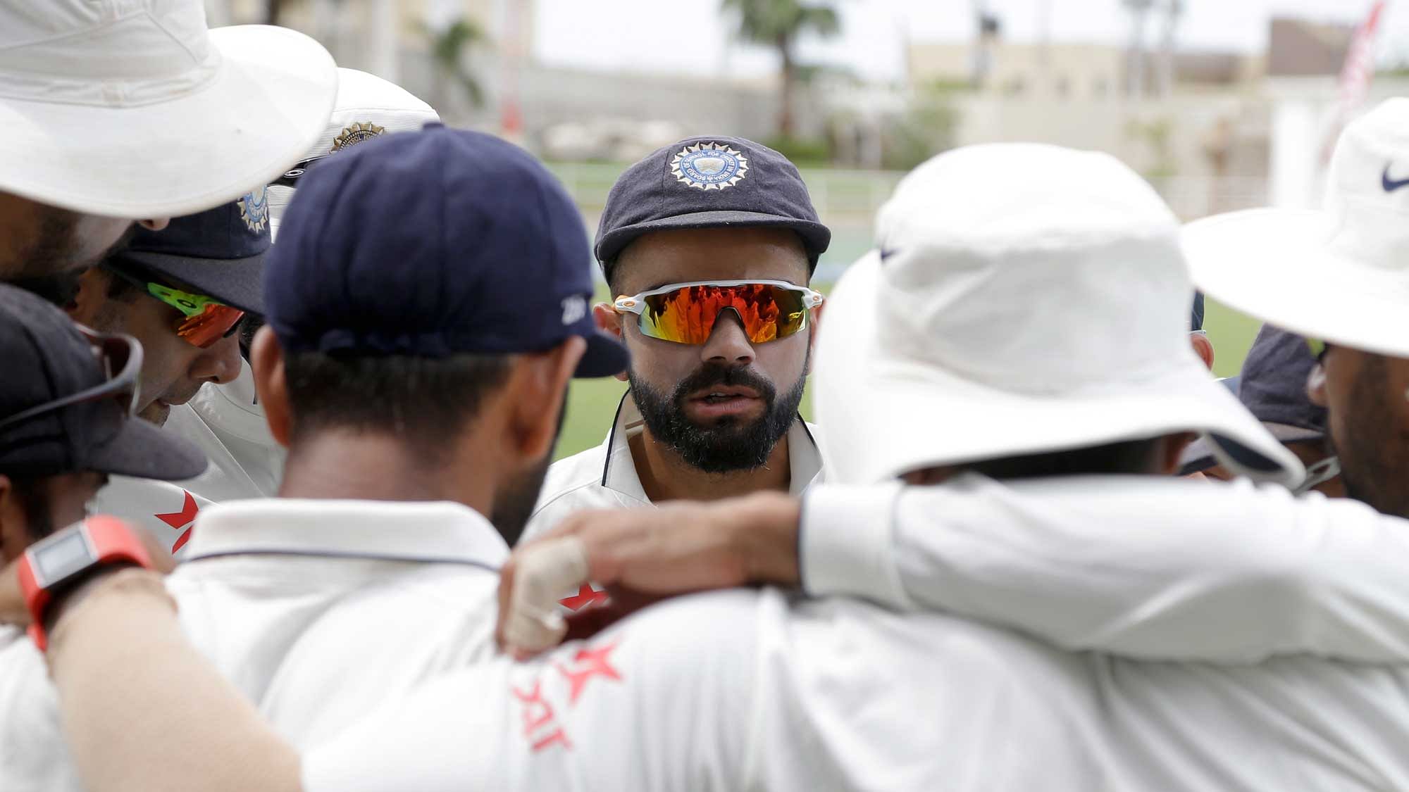 India’s captain Virat Kohli talks to teammates prior to the start of day one of their second Test match against West Indies at the Sabina Park (Photo: AP)