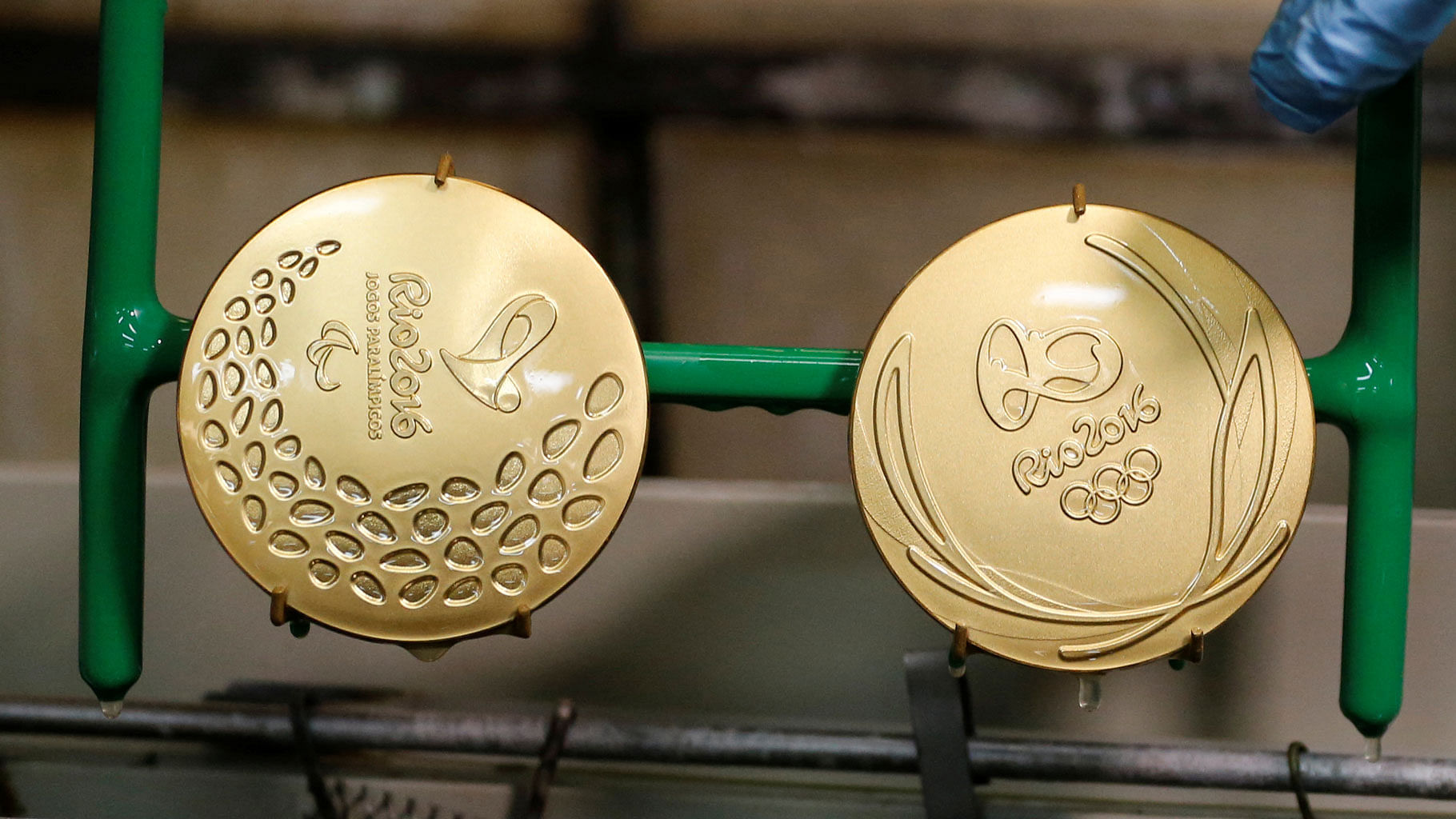A worker takes out gold-plated Olympic and Paralympic medals. (Photo: Reuters)