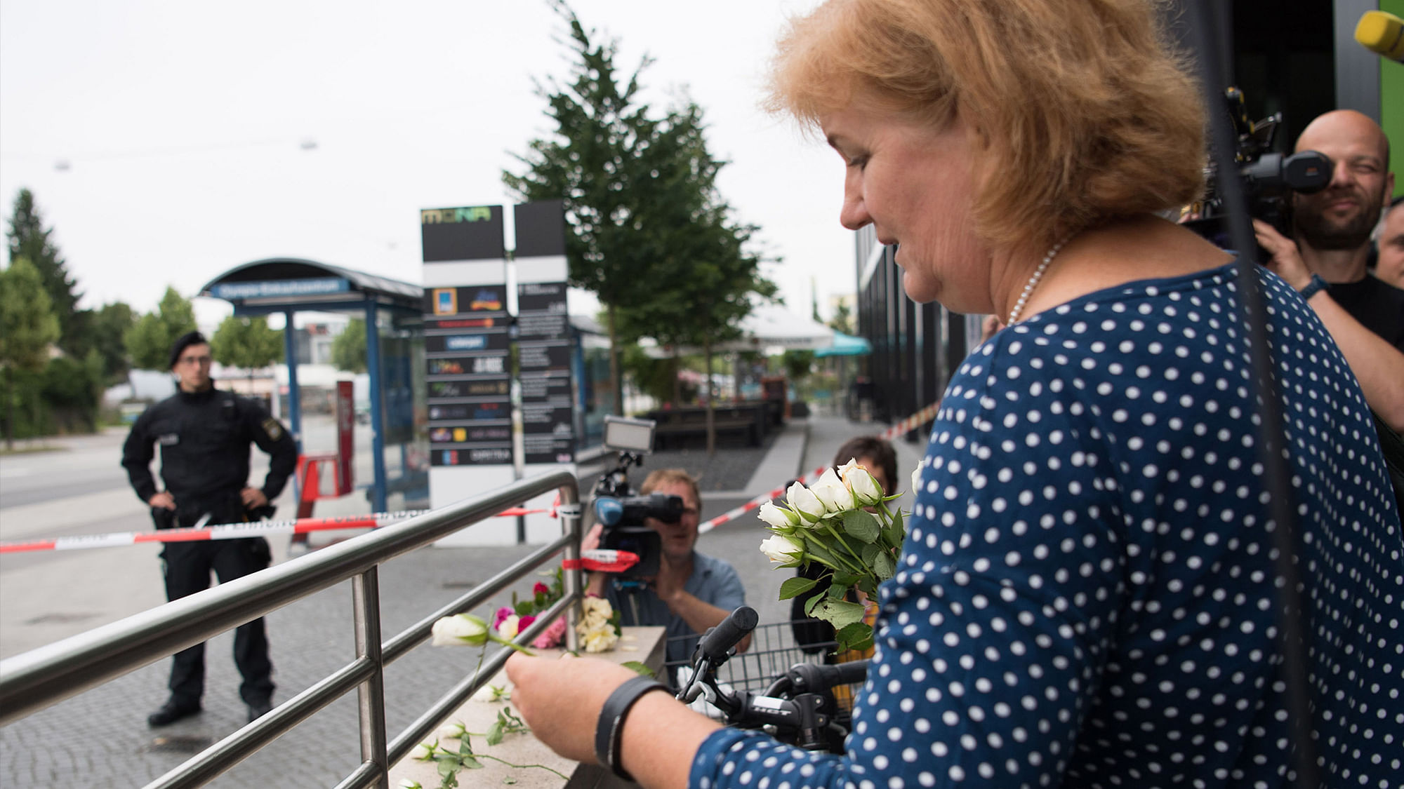 A woman puts down flowers near a mall where a shooting took place leaving nine people dead on Saturday. (Photo: AP)