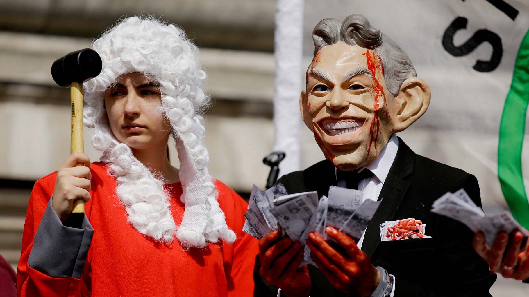 A protester wearing a former British Prime Minister Tony Blair mask (right) and another dressed as a judge in London on Wednesday, 6 July 2016. (Photo: AP)