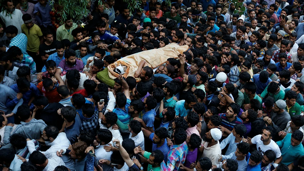 Kashmiri Muslims carry the body of Burhan Wani, a separatist militant leader, during his funeral in Tral, south of Srinagar on 9 July. 