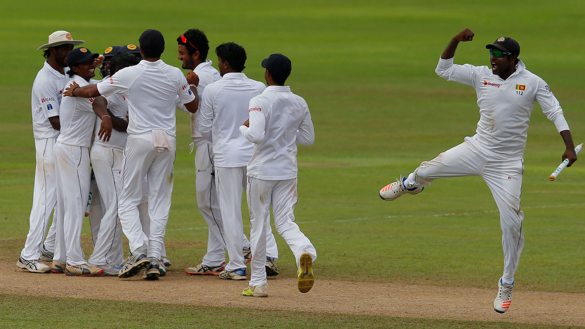 Sri Lankan captain Angelo Mathews celebrates with his team mates after defeating Australia by 106 runs in the 1st Test Match at Pallekele. (Photo: AP)