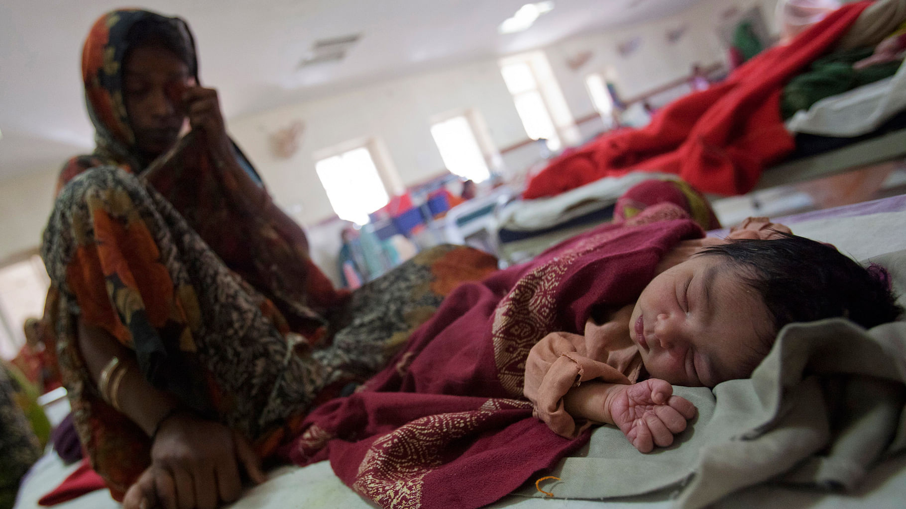 A woman sits on a bed along with her newborn baby at a district hospital in Shivpuri, Madhya Pradesh. (Photo: Reuters)