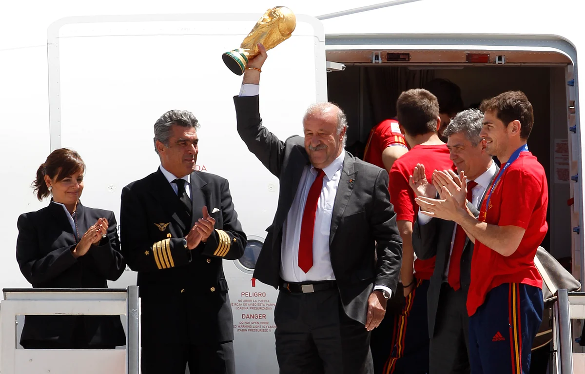 Spain’s coach Vicente del Bosque (L) next to Spain’s captain Iker Casillas lifts the World Cup trophy after arriving at Madrid’s Barajas airport on 12 July 2010. (Photo: Reuters) 