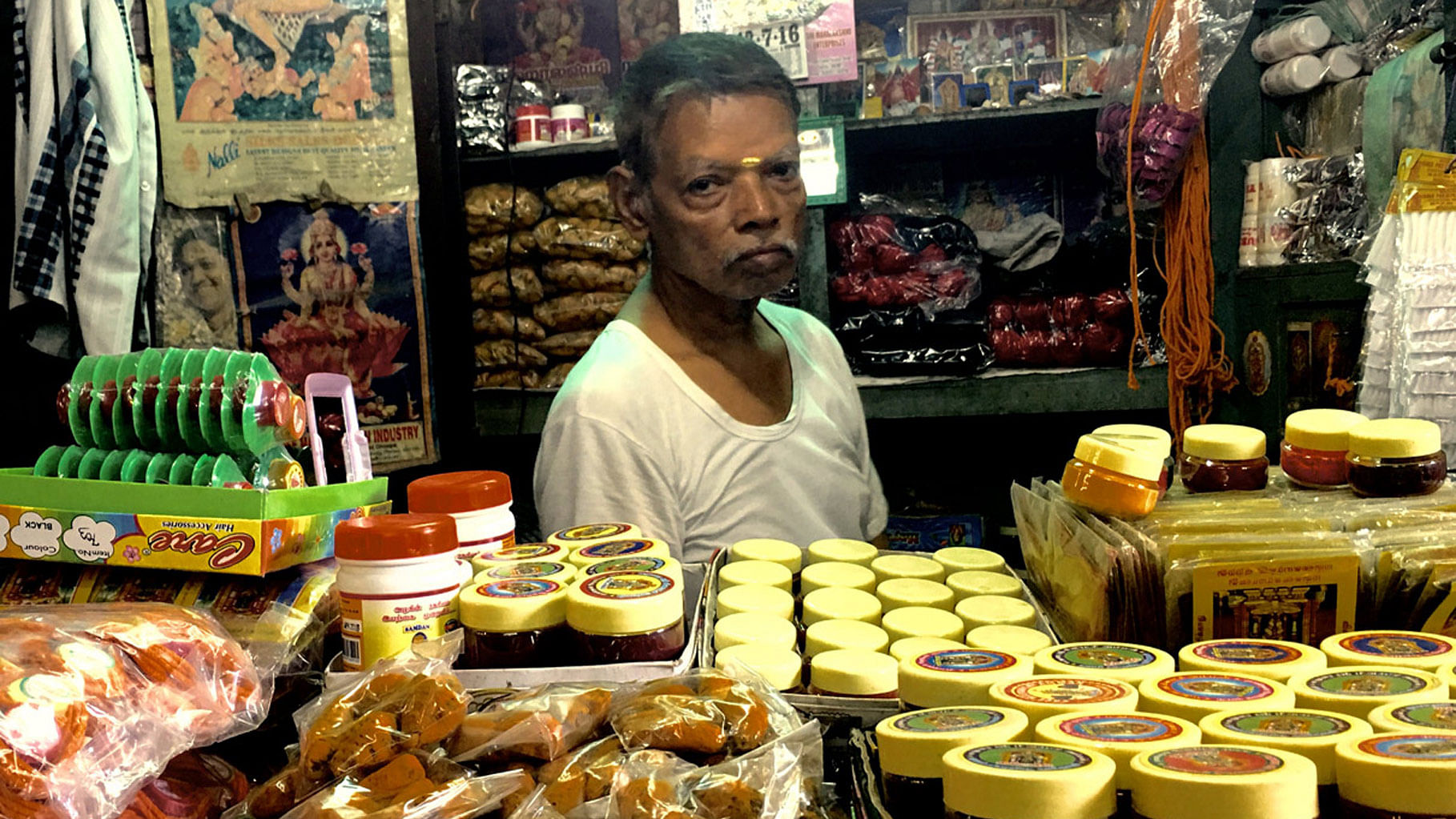 ‘Got Turmeric?’ : A shopkeeper at the <i>Puthu Mandapam </i>in Madurai. His is one among hundreds of tiny shops that sell curiosities and clothes. (Photo: Vikram Venkateswaran/<b>The Quint</b>)