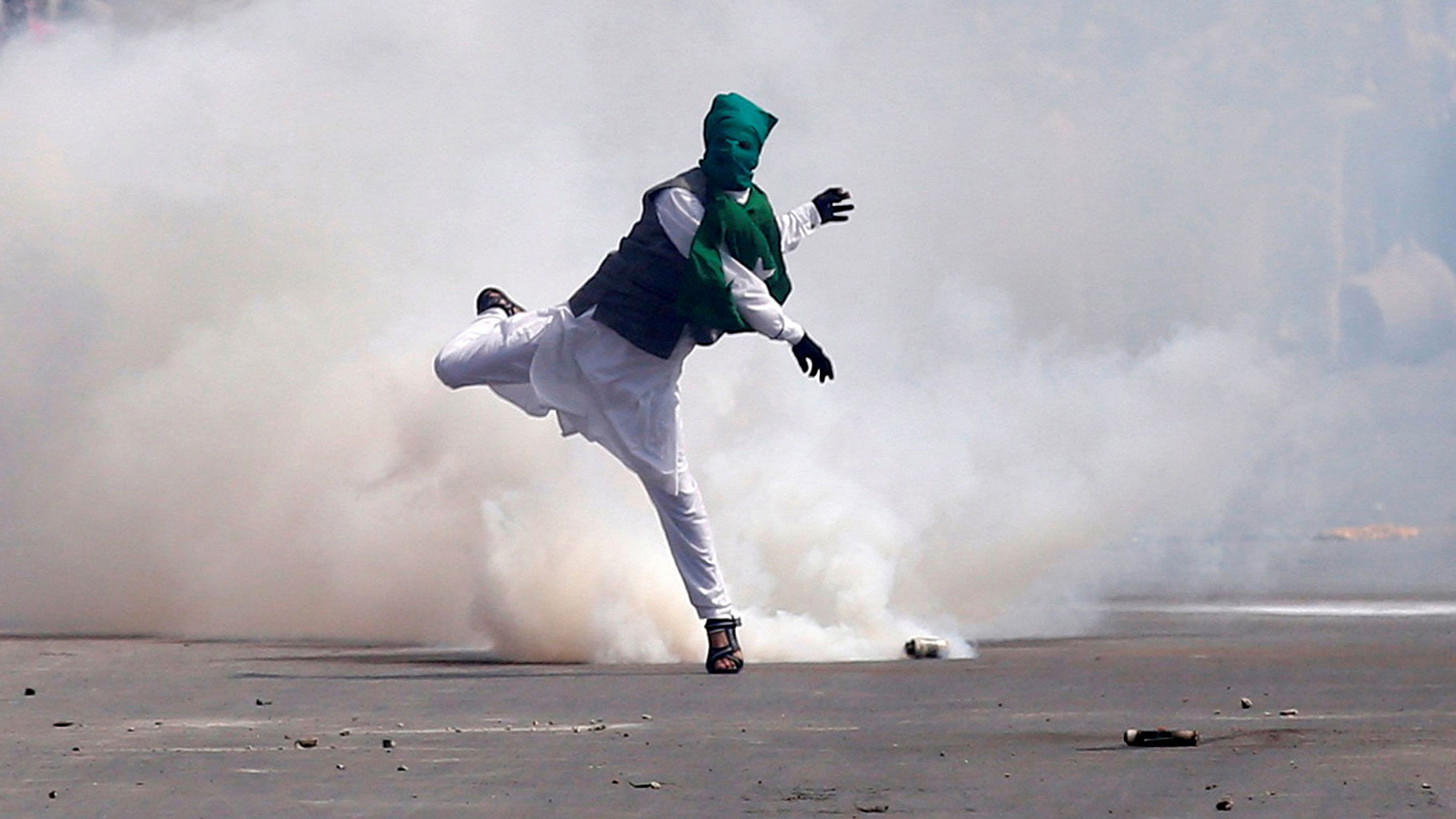 A demonstrator throws stones amid tear gas smoke fired by Indian police during a protest against what protesters say is the house arrest of Kashmiri separatist leaders, after Eid al-Fitr prayers in Srinagar. (Photo: Reuters)