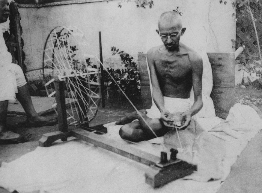 Mahatma Gandhi on his spinning wheel.