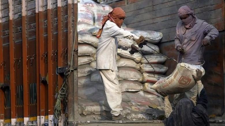 Workers unload cement bags from a truck near a construction site in New Delhi, India. Image used for representation.