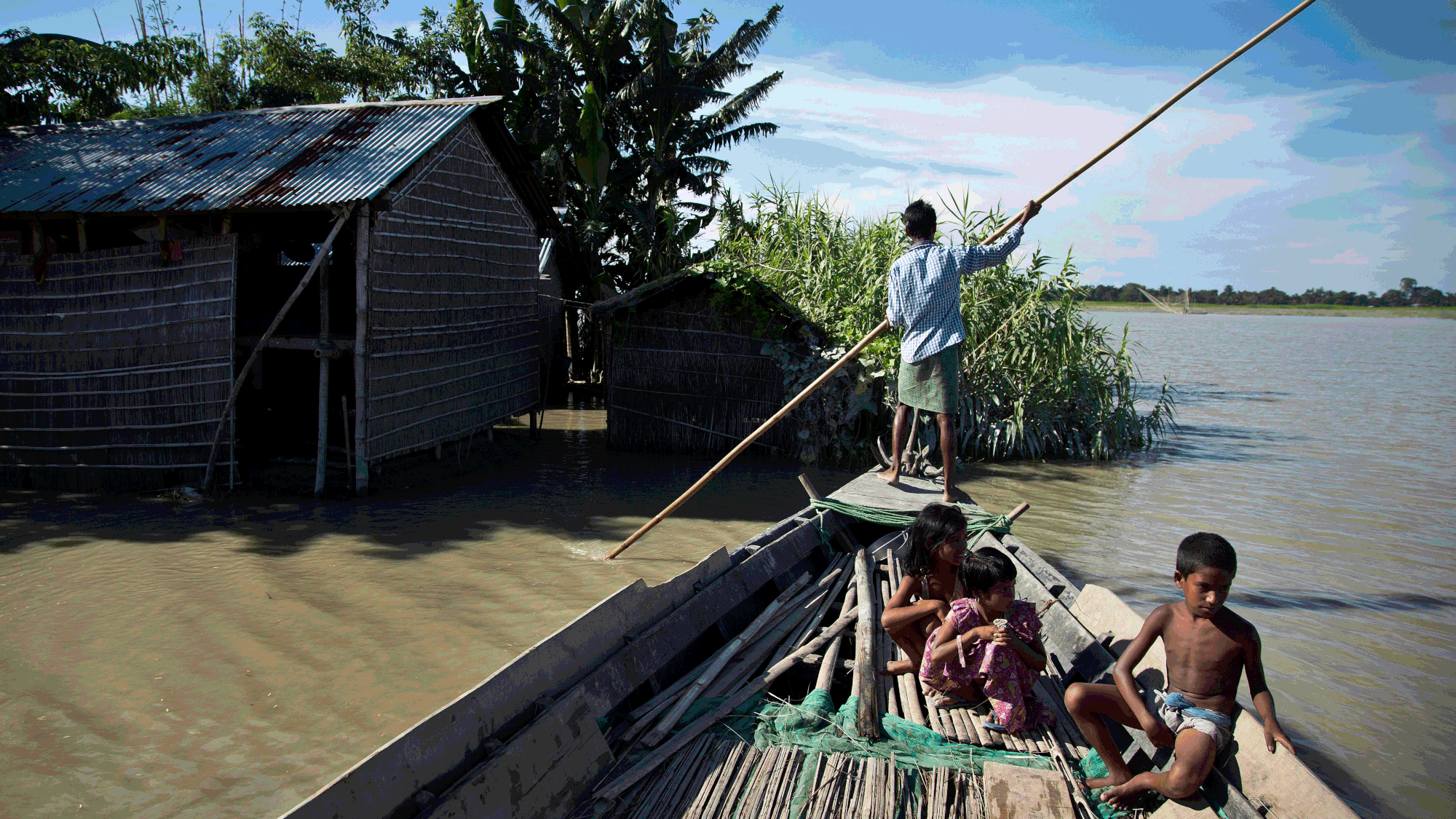 Flood affected villagers move on a boat in Morigaon district, east of Gauhati, Assam, July 2016. (Photo: AP)
