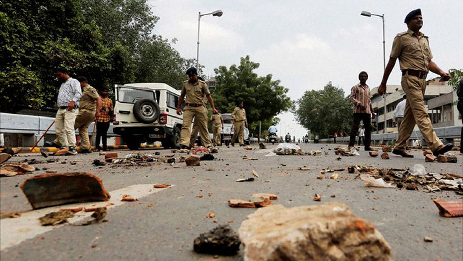 

Policemen remove stones put by members of Dalit community to block traffic during their protests in Ahmedabad. (Photo: PTI)
