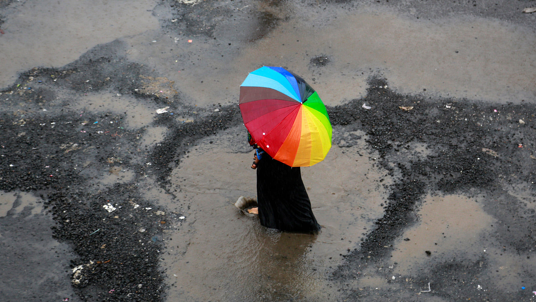 A woman holds an umbrella and walks through the rain in Mumbai. (Photo: AP)