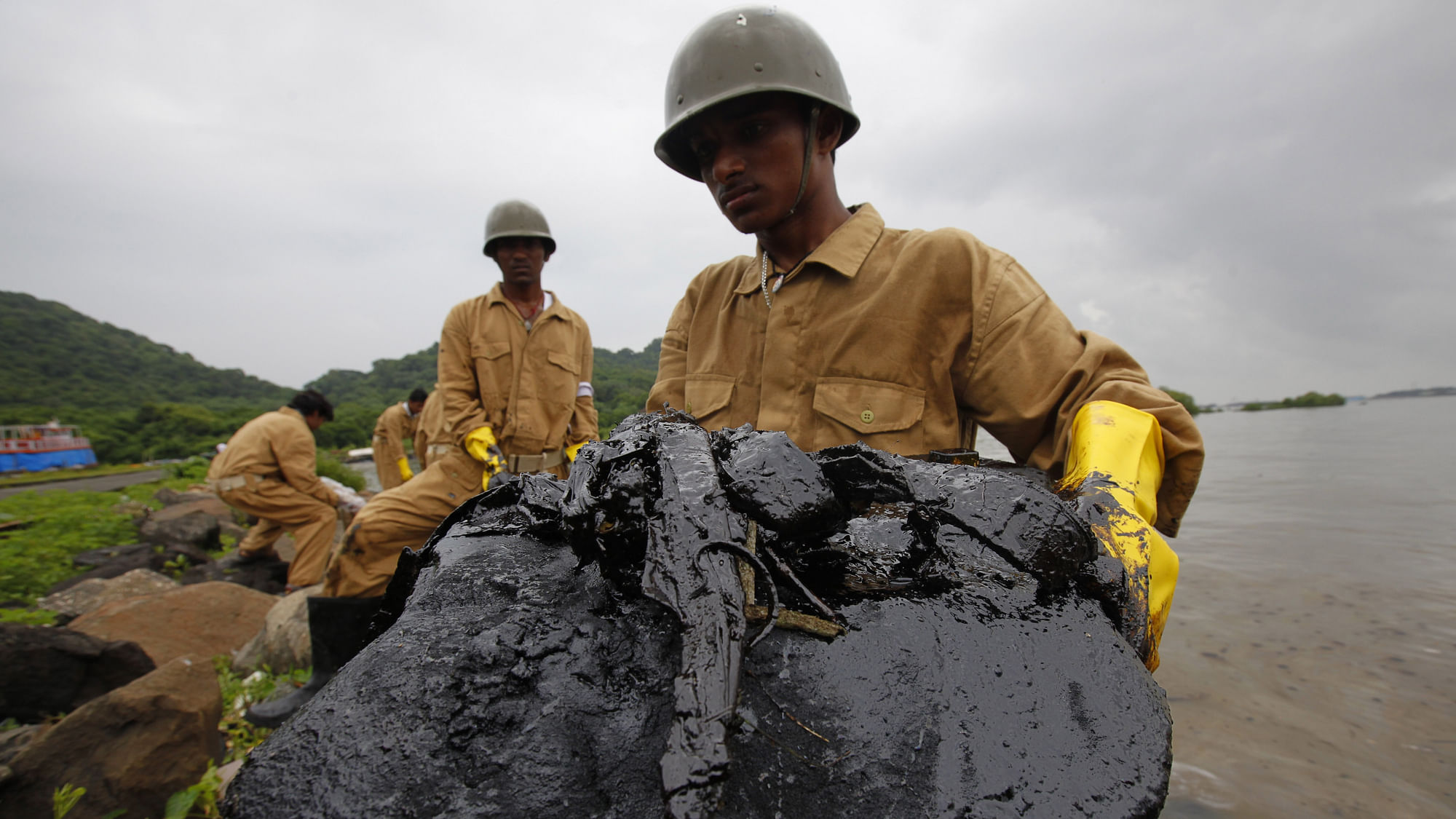 Civil defence personnel clean the slicked shores of Elephanta Island on the outskirts of Mumbai 12 August, 2010. Image for representation purposes only. (Photo: Reuters/Danish Siddiqui)