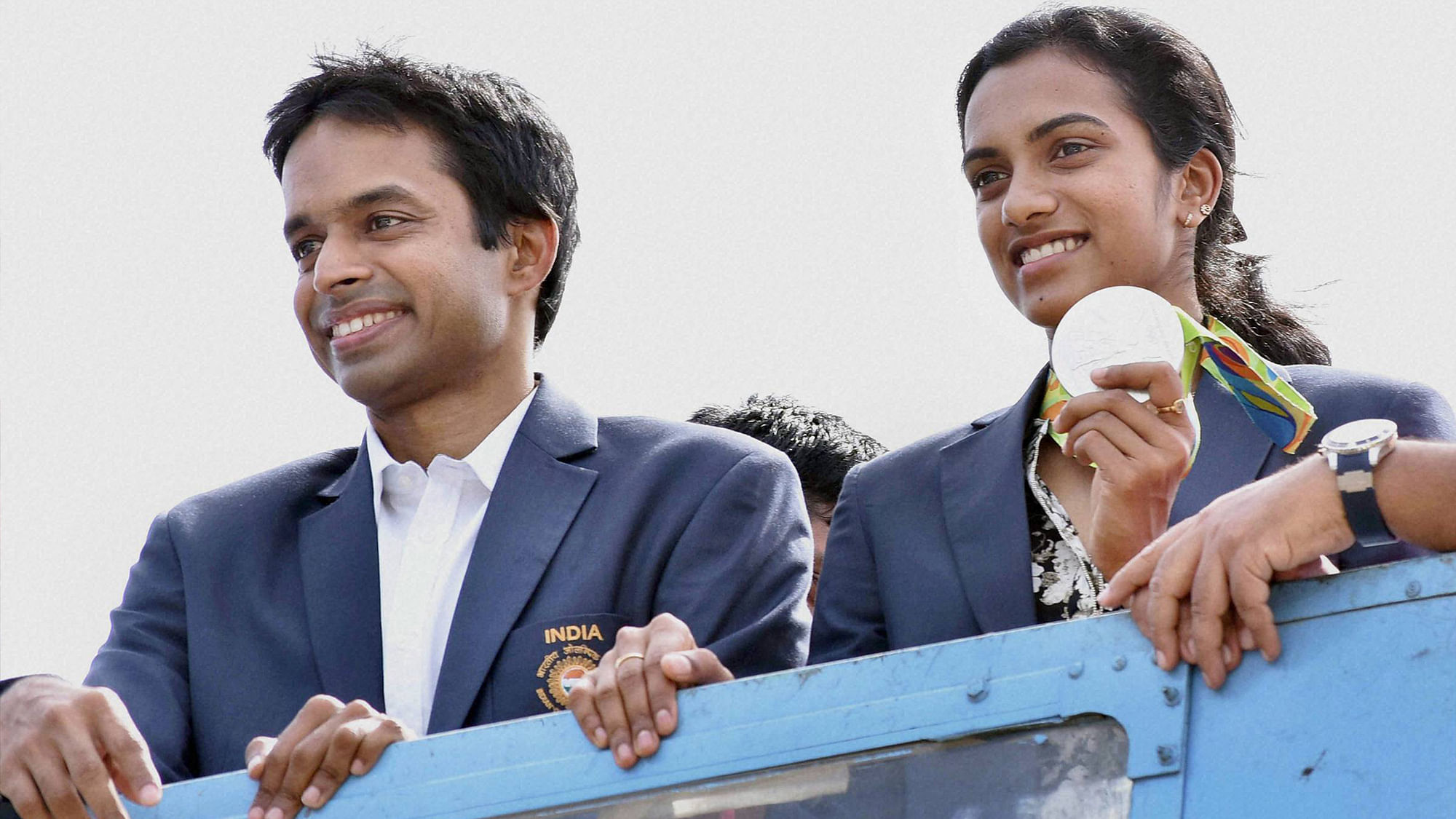 Olympic Silver Medalist P.V.Sindhu with her Coach Gopi Chand flaunts her medal after her arrival at Rajiv Gandhi International Airport in Hyderabad on Monday. (Photo: PTI)
