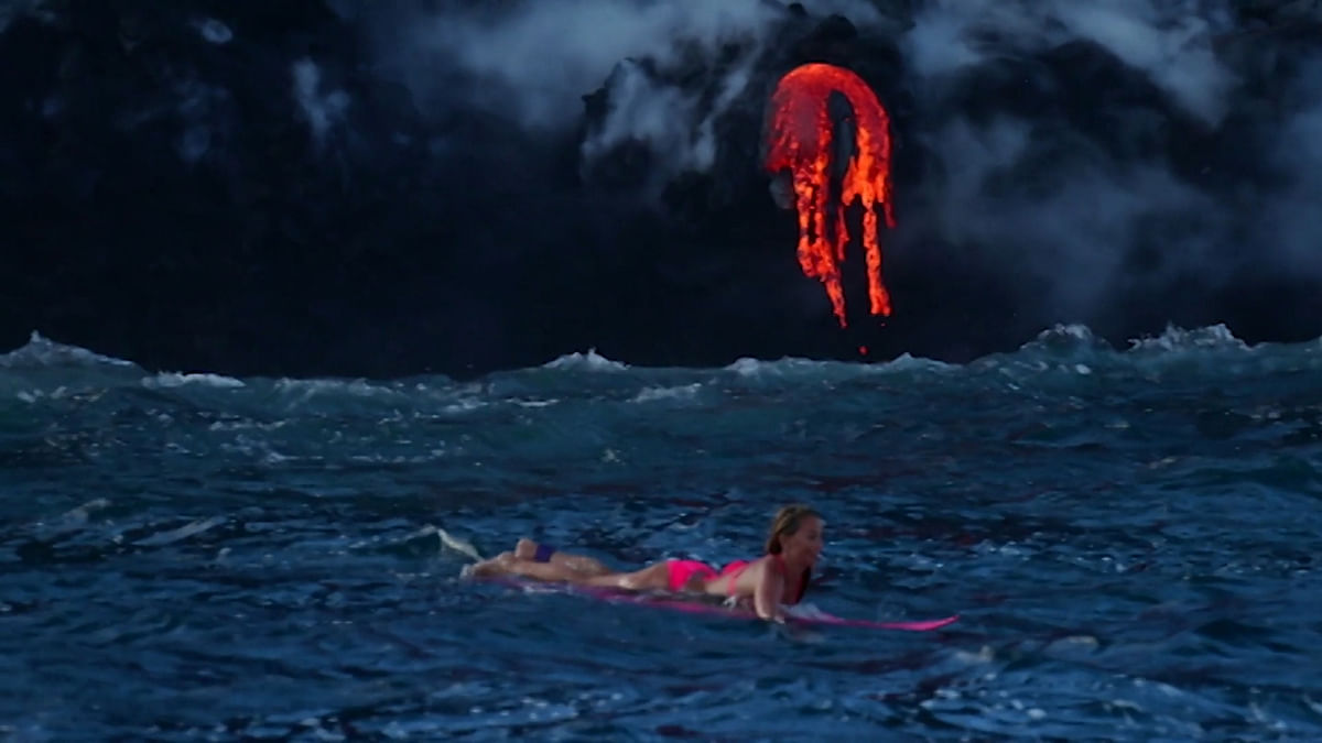 Woman Surfs at Base of an Erupting Volcano in Hawaii