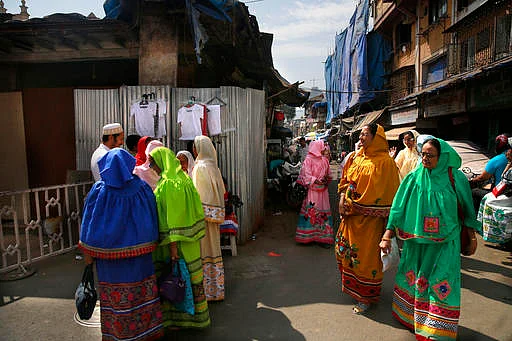 Dawoodi Bohra women walk past others shopping for clothes in a Bohra neighborhood in Mumbai. The Dawoodi Bohras are an affluent trading community of about a million people concentrated mostly in Mumbai, but also seen across the United States and Europe. (Photo Courtesy: AP Images)