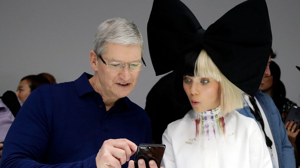 Apple CEO Tim Cook shows an iPhone 7 to performer Maddie Ziegler during an event to announce new products, Wednesday, in San Francisco. (Photo: AP Photo)<a></a>