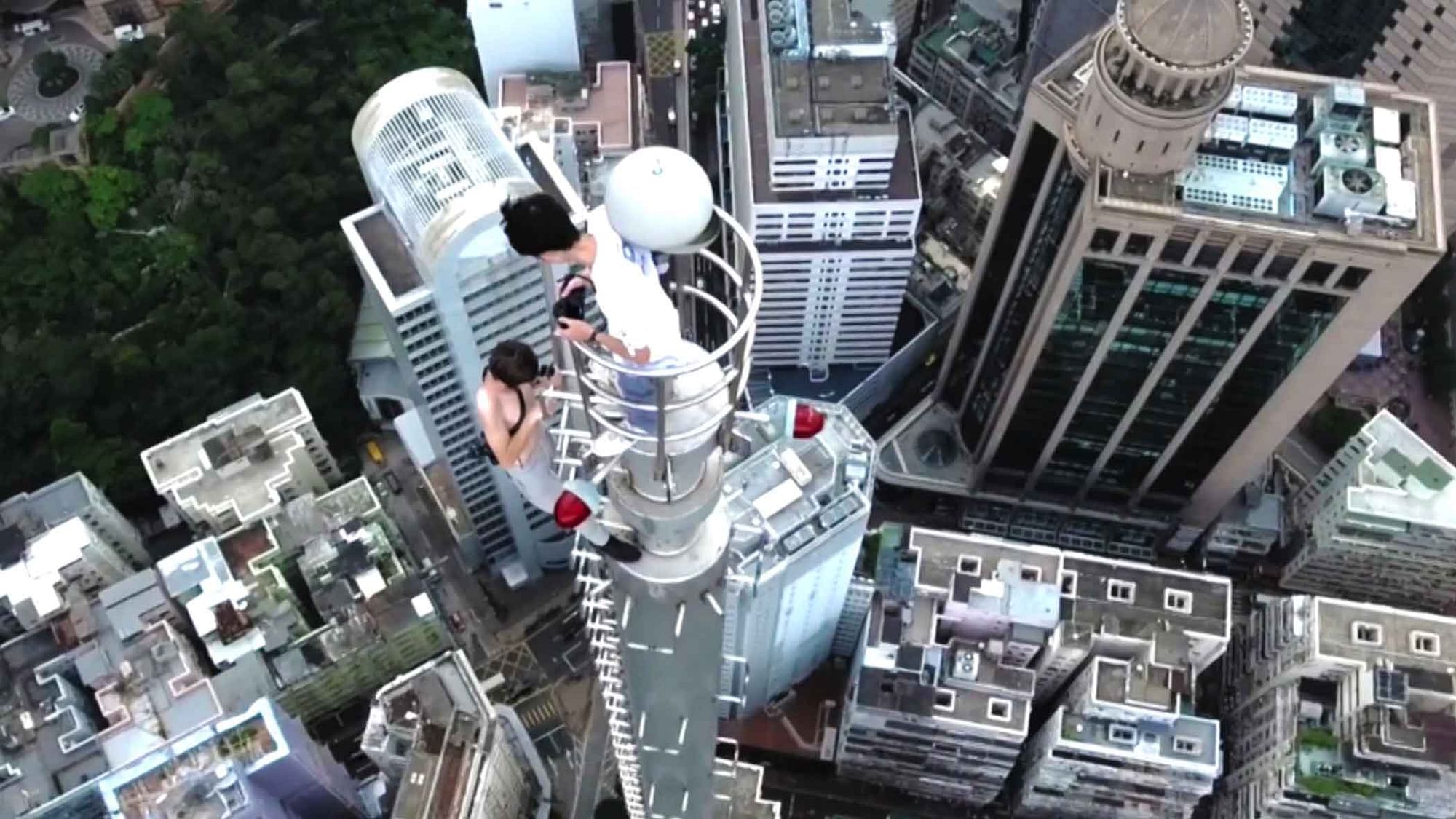 Thrill seekers on top of the 240-metre high building in Hong Kong. (Photo: AP Screengrab)
