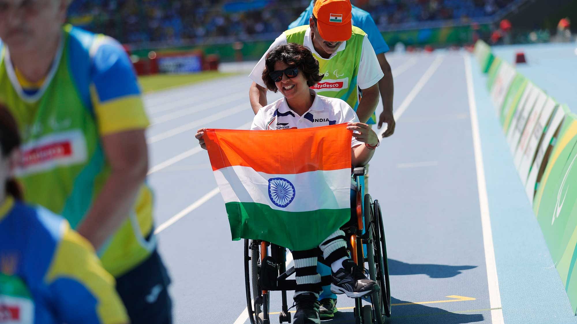 India’s Deepa Malik holds the nation’s flag after winning the silver medal in the women’s shot put F53 athletics event during the Paralympic Games. (Photo: AP)