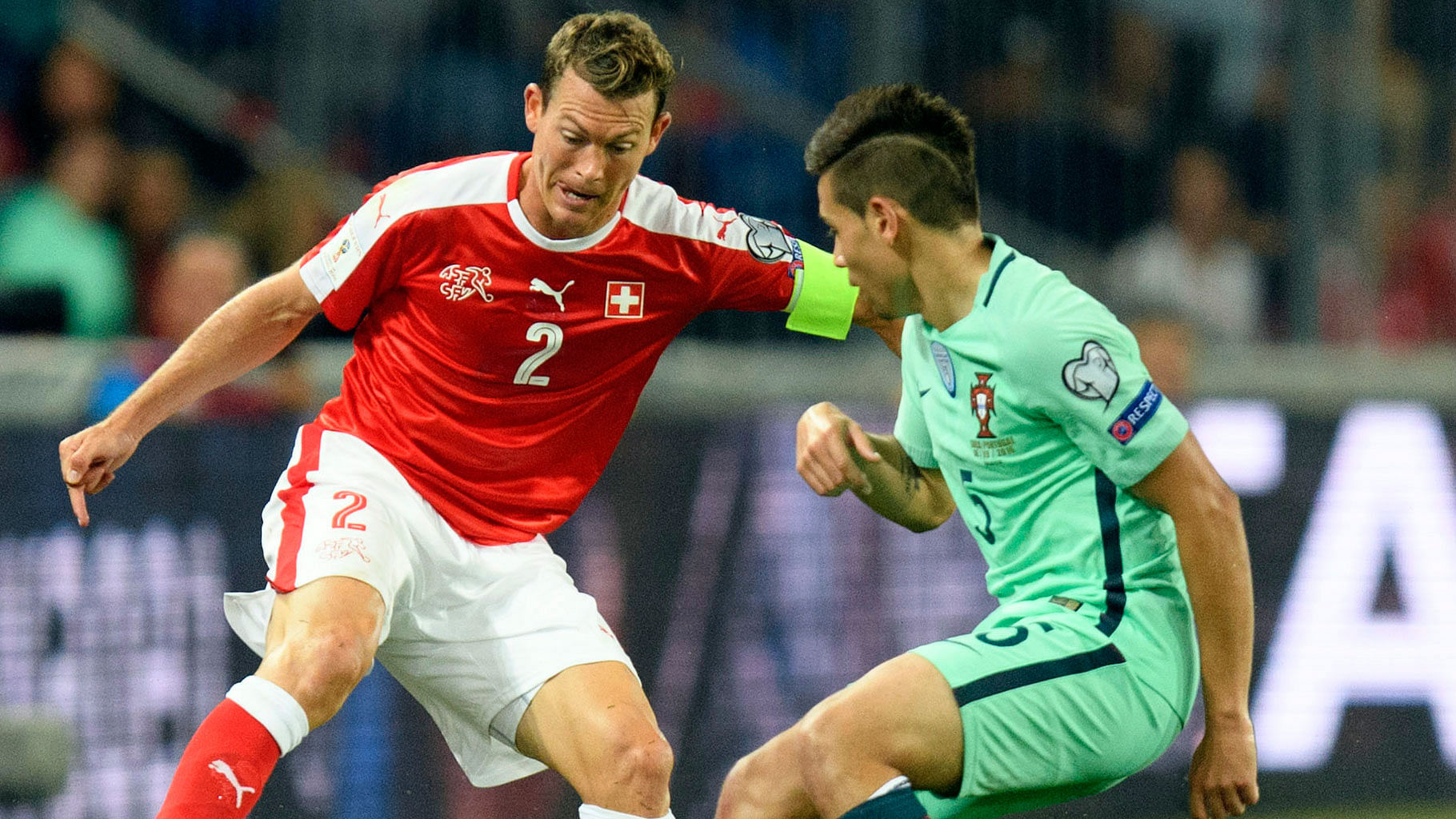 Switzerland’s Stephan Lichtsteiner, left, battles for the ball with Portugal’s Raphael Guerreiro. (Photo: AP)