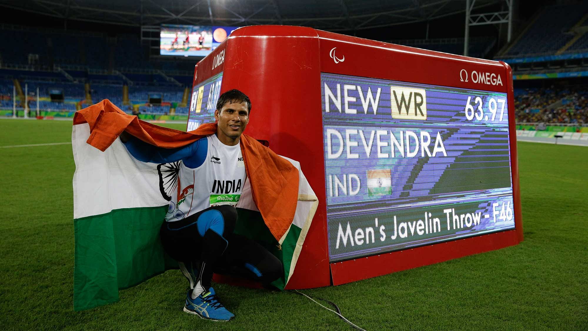 India’s Devendra Jhajharia poses for the pictures next to the scoreboard that shows his world record in the men’s javelin throw F46 athletics event at the Paralympic Games. (Photo: AP)<a></a>