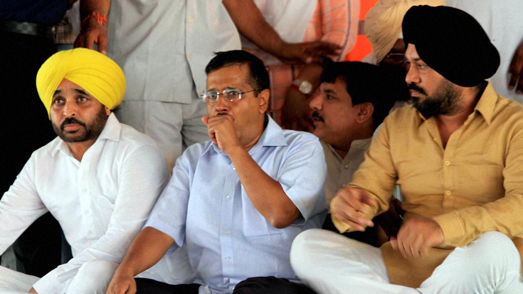 Arvind Kejriwal flanked by AAP Punjab convener, comedian-turned-politician Gurpreet Ghuggi (right) , and AAP MPs from Punjab, Bhagwant Mann (left). (Photo: PTI)