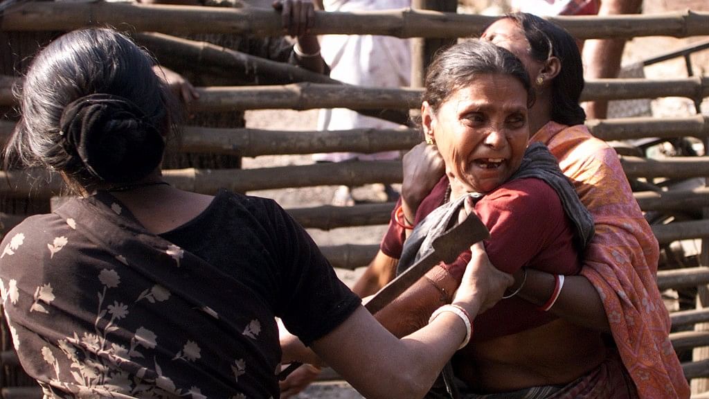 An Indian slum dweller attempts to stop a woman from trying to prevent an eviction drive by government authorities. (Photo: Reuters)