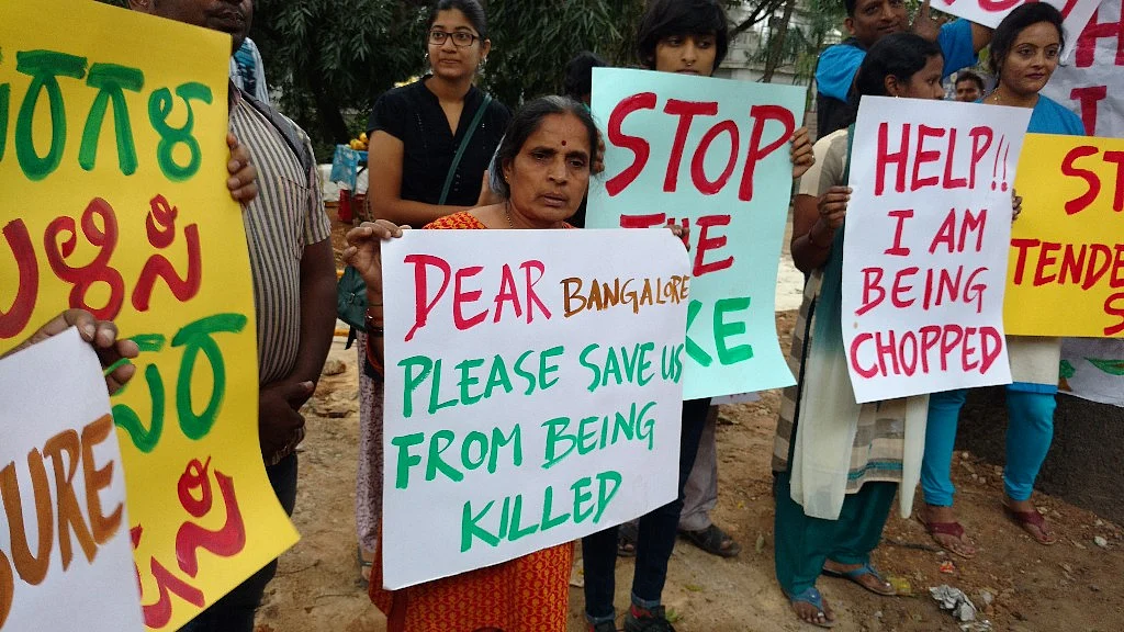 People protesting against tree felling along the Nrupathunga road in Bengaluru. (Photo: Subir Ghosh/ <b>The Quint</b>)