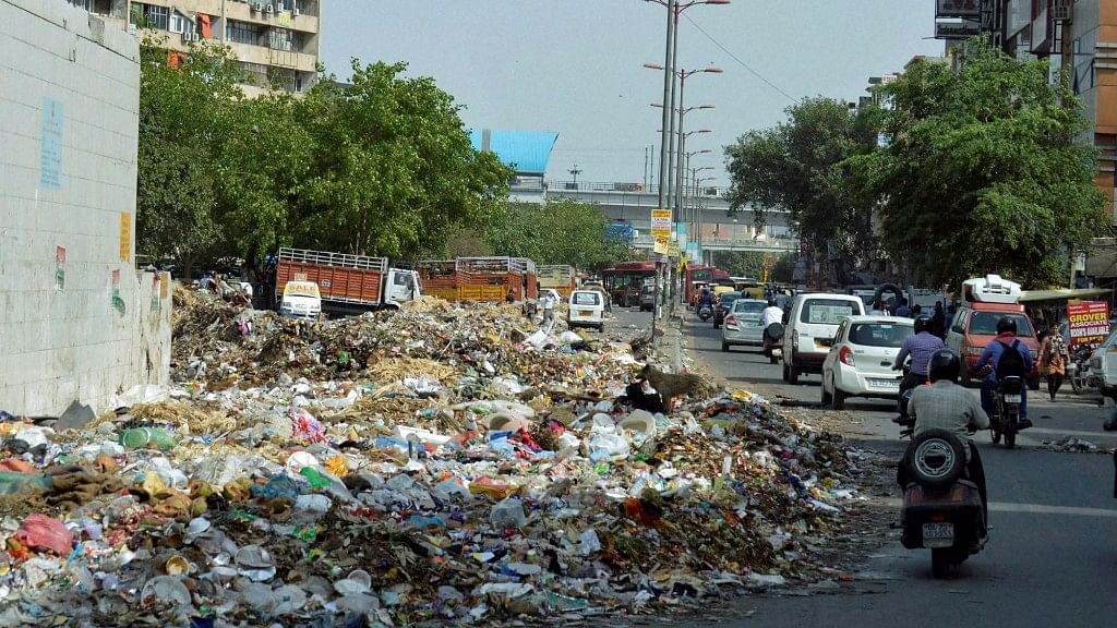  Garbage dumped on road near Nirman Vihar metro station as MCD workers went on strike due to non-payment of salaries in New Delhi. (Photo: PTI)&nbsp;