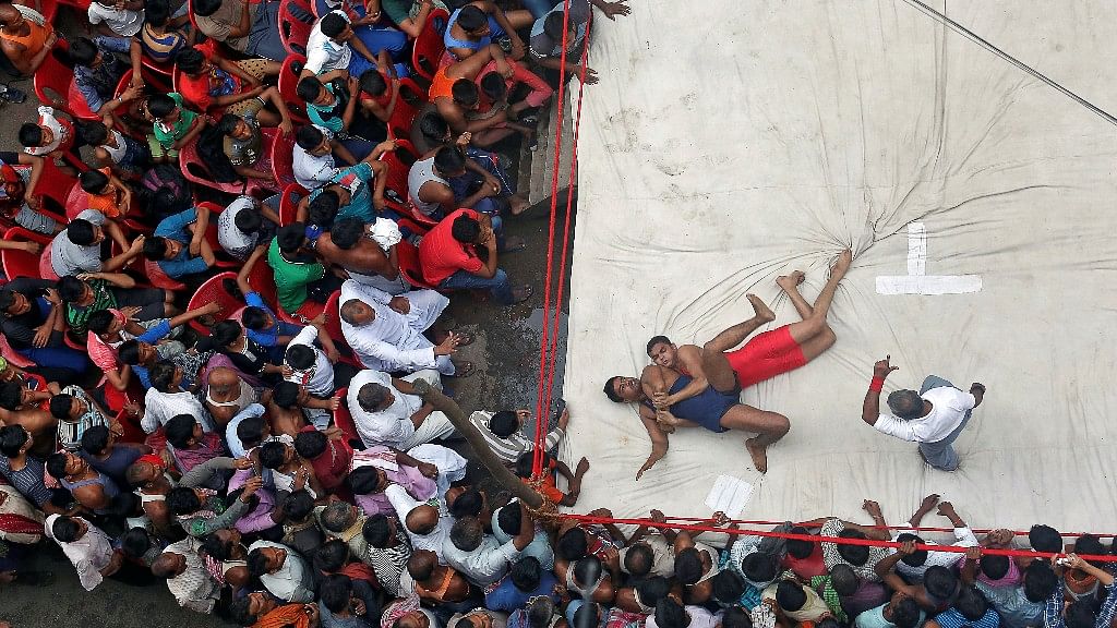 Wrestlers fight during an amateur wrestling match inside a makeshift ring installed on a road organised by local residents as part of the Diwali celebrations in Kolkata. (Photo: Reuters/Rupak De Chowdhuri)