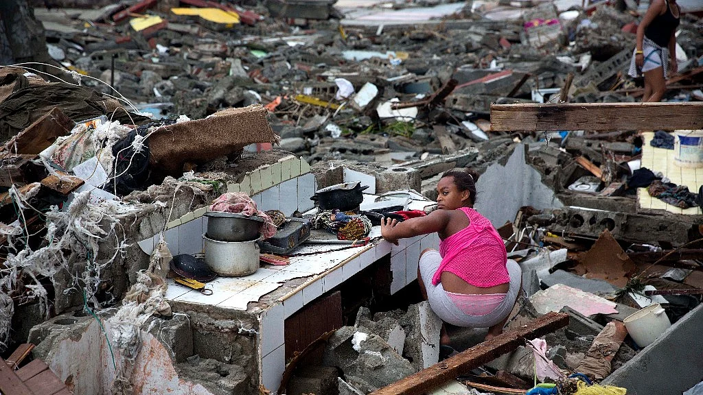 A woman searches amid the rubble of her home destroyed by Hurricane Matthew in Baracoa, Cuba. (Photo: AP)