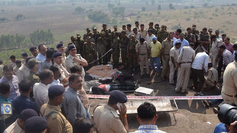 MP Police and locals surrounding the bodies of the SIMI suspects after the alleged encounter. (Photo: IANS)