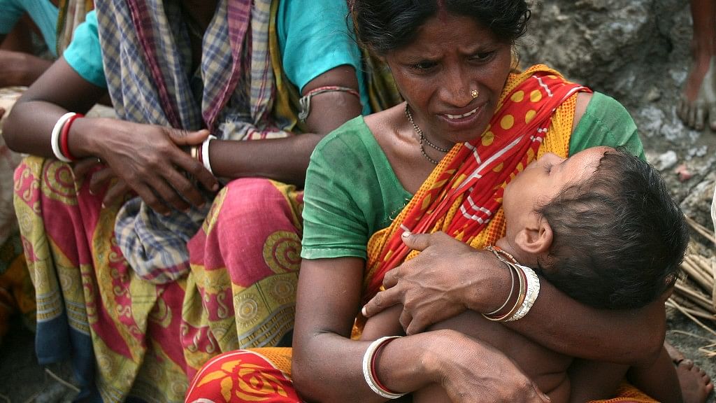 A woman grasps her child in the wake of Cyclone Aila in West Bengal in 2009. (Photo: Reuters)