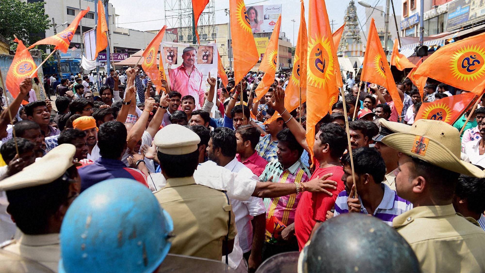 Police and RAF stop protestors in Shivaji Nagar area during a protest rally over the murder of an RSS worker in Bengaluru on Monday. (Photo: PTI)
