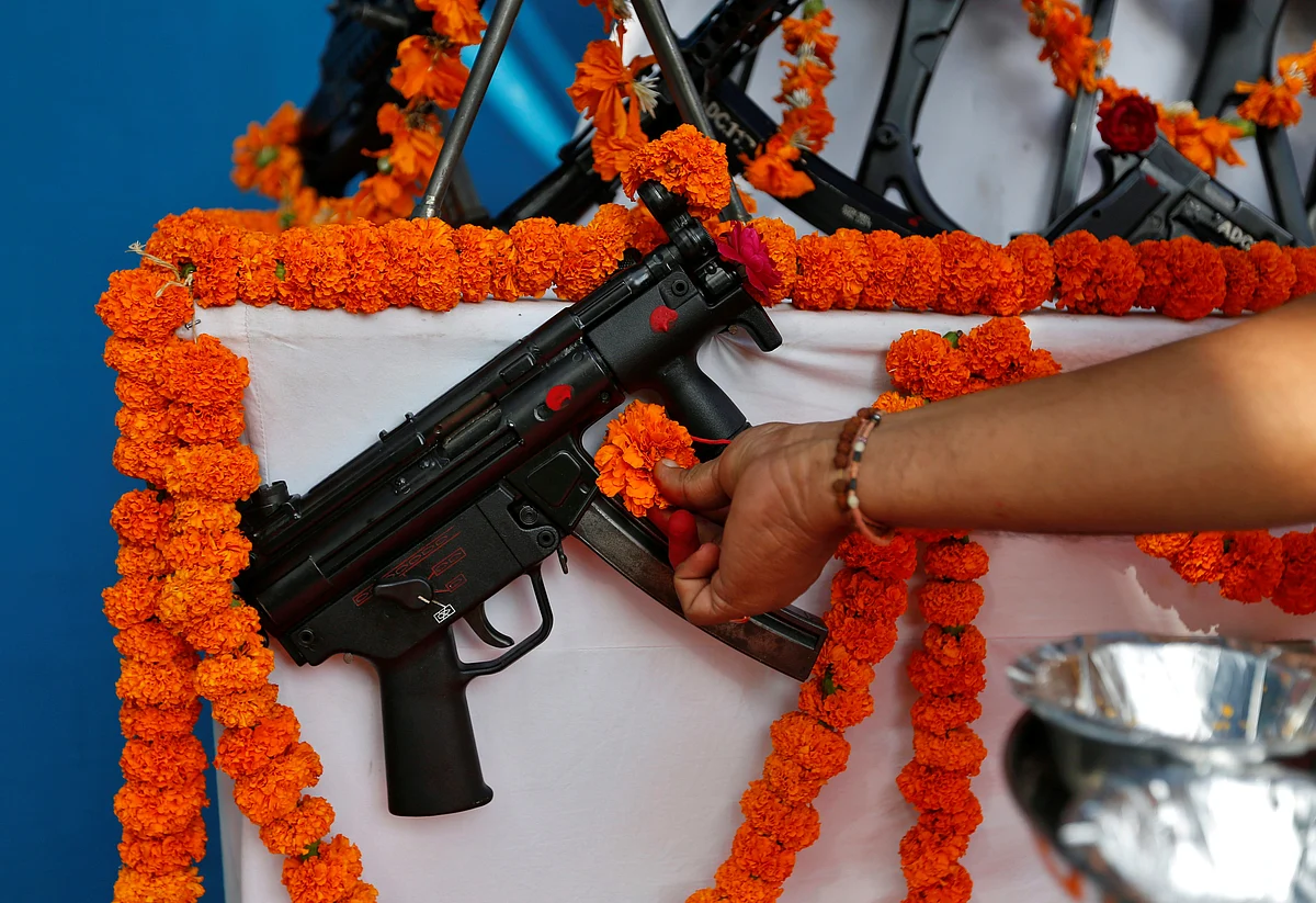 A priest offers prayers to a weapon at the police headquarters on the occasion of Dussehra in Ahmedabad. (Photo: Reuters/Amit Dave)
